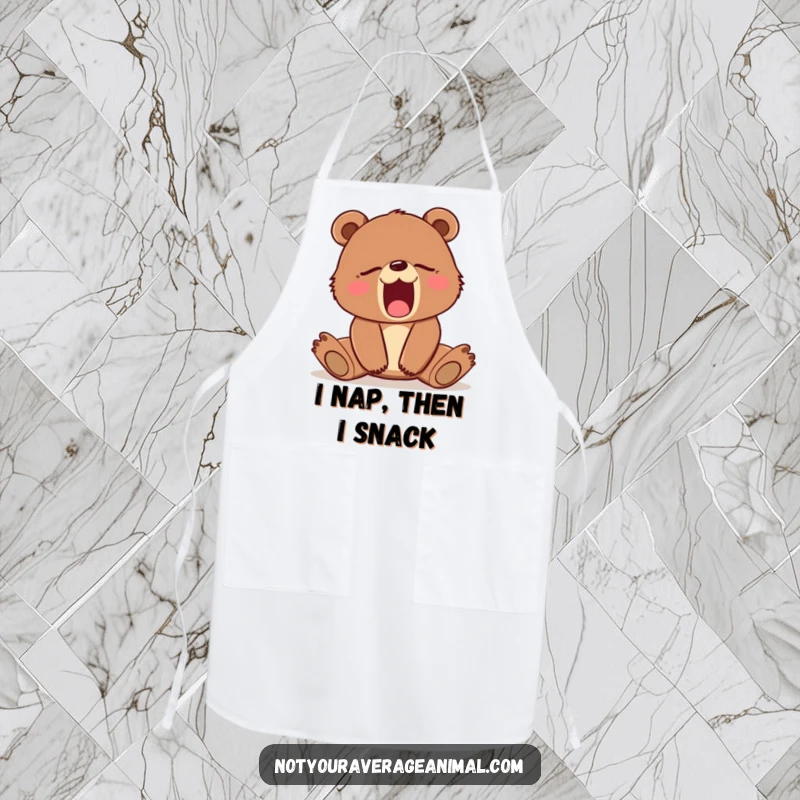 Funny apron depicting a sleepy brown bear cub yawning widely, ready for kitchen duty. A humorous cooking accessory.