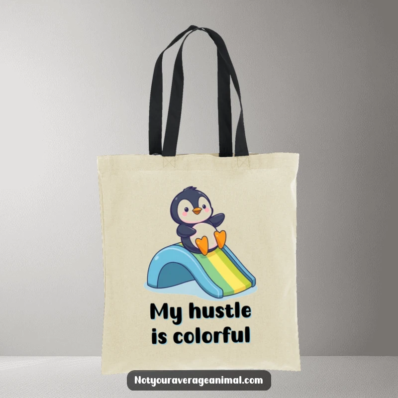 Funny tote bag featuring a gleeful penguin on a vibrant rainbow slide, perfect for carrying smiles and essentials.